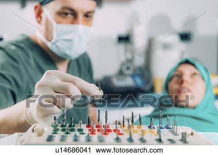 Dentist installing dental implant View Large Photo Image Stock Image - Dentist installing dental implant. Fotosearch