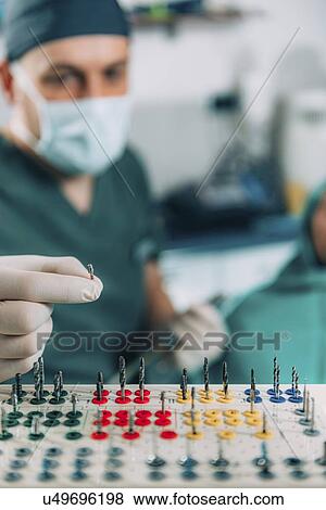 Dentist installing dental implant View Large Photo Image Stock Photo - Dentist installing dental implant. Fotosearch