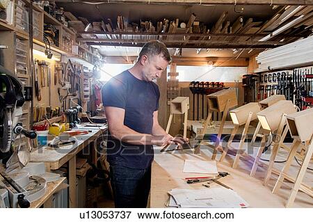 Designer using digital tablet by prototypes of table lamps View Large Photo Image Stock Photo - Designer using digital tablet by prototypes of table lamps. Fotosearch