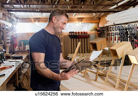 Designer using digital tablet by prototypes of table lamps View Large Photo Image Stock Photograph - Designer using digital tablet by prototypes of table lamps. Fotosearch