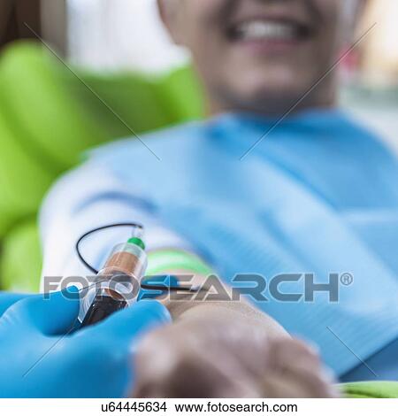 Picture - Drawing blood for platelet-rich plasma (PRP) treatment. Close-up of doctor drawing blood for a PRP cosmetics treatment.. Fotosearch
