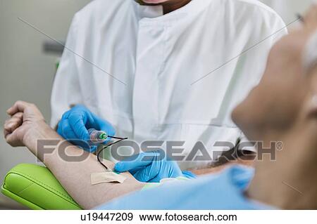 Stock Photo - Drawing blood for platelet-rich plasma (PRP) treatment. Doctor drawing blood for a PRP cosmetics treatment.. Fotosearch