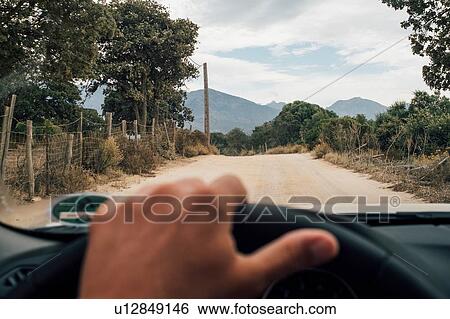 Driver behind wheel of car, road ahead, Calvi, Corse, France View Large Photo Image Stock Photograph - Driver behind wheel of car, road ahead, Calvi, Corse, France. Fotosearch