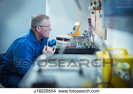 Picture - Engineer pressure testing sensors in nuclear power station during outage. Fotosearch