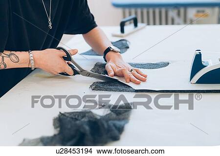 Picture - Fashion designer cutting fabric from dressmaker's pattern. Fotosearch