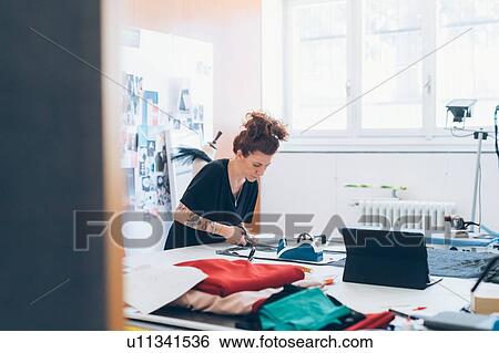 Fashion designer cutting fabric from dressmaker's pattern View Large Photo Image Stock Photograph - Fashion designer cutting fabric from dressmaker's pattern. Fotosearch