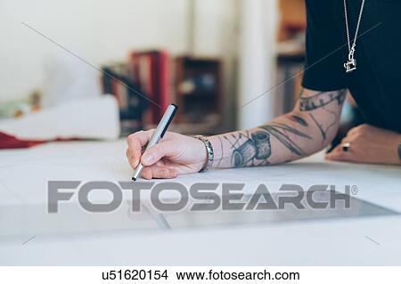 Picture - Fashion designer drawing and creating dressmaker's pattern. Fotosearch
