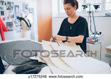 Stock Photo - Fashion designer laying out dressmaker's pattern. Fotosearch