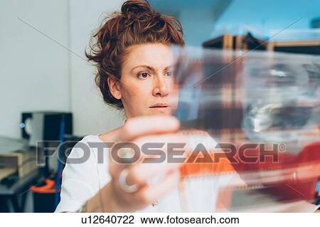 Fashion designer looking at film negative View Large Photo Image Stock Image - Fashion designer looking at film negative. Fotosearch