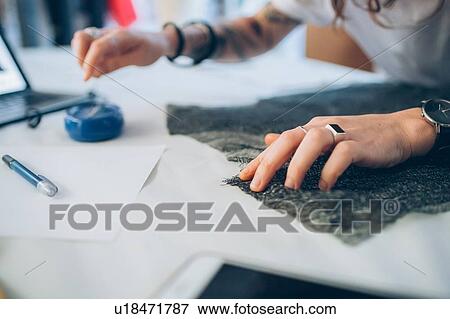 Stock Photo - Fashion designer pinning fabric cutouts. Fotosearch