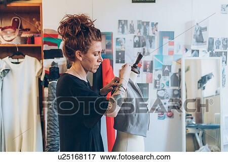 Fashion designer pinning garment onto dressmaker's dummy View Large Photo Image Stock Photo - Fashion designer pinning garment onto dressmaker's dummy. Fotosearch
