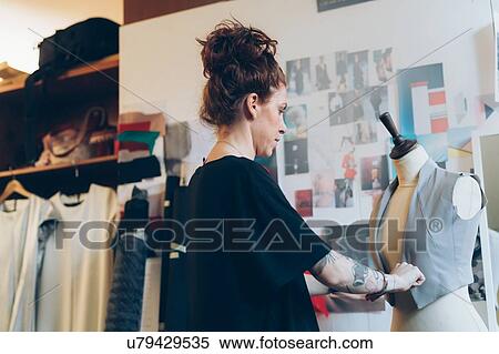 Stock Photography - Fashion designer pinning garment onto dressmaker's dummy. Fotosearch