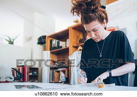 Stock Image - Fashion designer working in her studio. Fotosearch