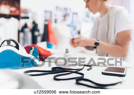 Stock Photograph - Fashion designer working in her studio. Fotosearch