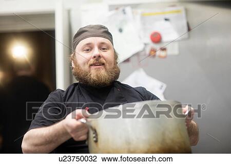 Fast food worker carrying large pan in commercial kitchen, portrait View Large Photo Image Stock Image - Fast food worker carrying large pan in commercial kitchen, portrait. Fotosearch