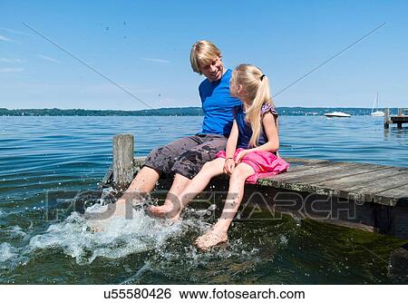 Father and daughter cooling feet in water, Lake Starnberg, Bavaria, Germany View Large Photo Image Stock Photograph - Father and daughter cooling feet in water, Lake Starnberg, Bavaria, Germany. Fotosearch