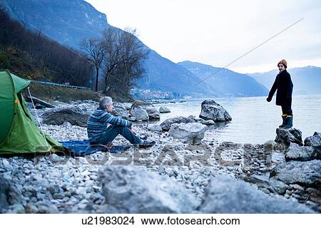 Picture - Father and son camping by lakeside, Onno, Lombardy, Italy. Fotosearch