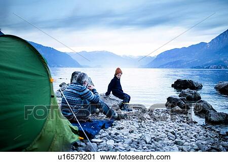 Father and son camping by lakeside, Onno, Lombardy, Italy View Large Photo Image Stock Image - Father and son camping by lakeside, Onno, Lombardy, Italy. Fotosearch