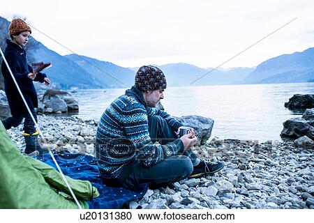 Father and son camping by lakeside, Onno, Lombardy, Italy View Large Photo Image Stock Image - Father and son camping by lakeside, Onno, Lombardy, Italy. Fotosearch