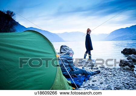 Stock Photograph - Father and son camping by lakeside, Onno, Lombardy, Italy. Fotosearch