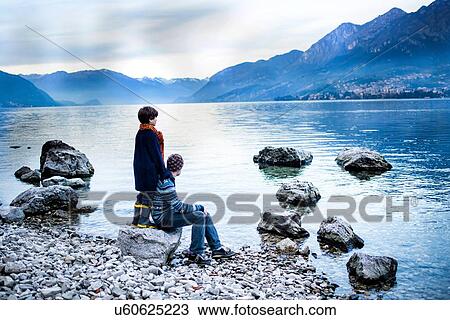 Father and son on lakeside, Onno, Lombardy, Italy View Large Photo Image Stock Image - Father and son on lakeside, Onno, Lombardy, Italy. Fotosearch