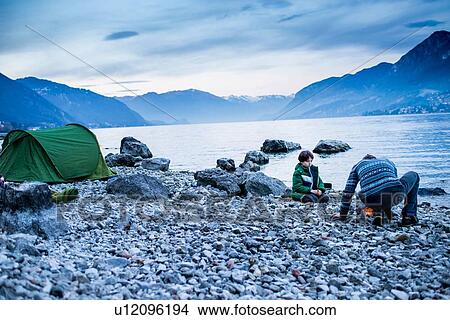 Father and son starting campfire, Onno, Lombardy, Italy View Large Photo Image Picture - Father and son starting campfire, Onno, Lombardy, Italy. Fotosearch
