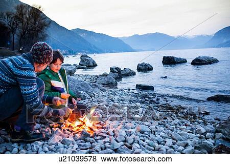 Father and son toasting marshmallows over campfire, Onno, Lombardy, Italy View Large Photo Image Stock Photo - Father and son toasting marshmallows over campfire, Onno, Lombardy, Italy. Fotosearch