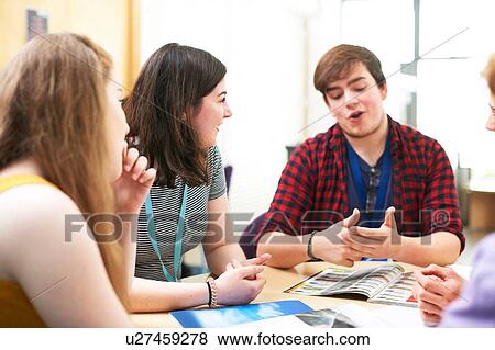 Stock Photo - Female and male higher education students talking in college classroom. Fotosearch