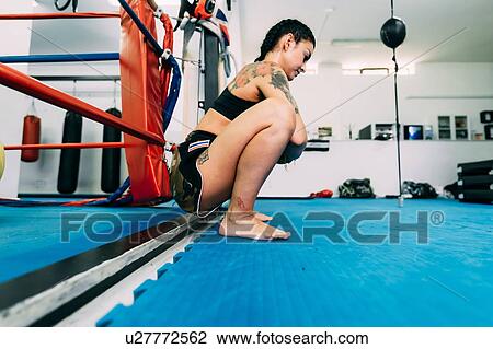 Female boxer squatting by boxing ring ropes View Large Photo Image Stock Image - Female boxer squatting by boxing ring ropes. Fotosearch