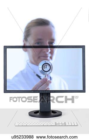 Stock Photo - Female doctor with stethoscope reaching out from computer screen. Telehealth or remote medical assistance.. Fotosearch