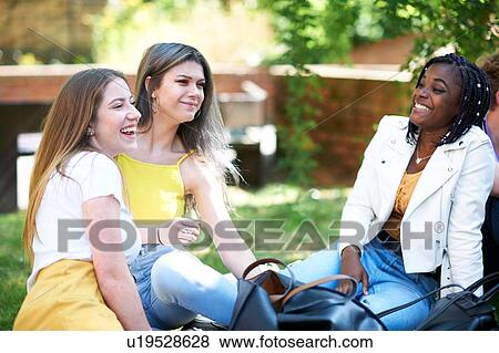 Stock Photo - Female higher education students chatting on college campus lawn. Fotosearch