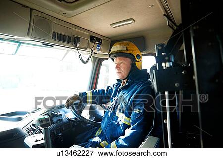 Fireman at wheel of fire engine View Large Photo Image Stock Photo - Fireman at wheel of fire engine. Fotosearch