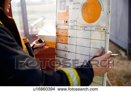 Picture - Fireman looking at chart at training centre. Fotosearch