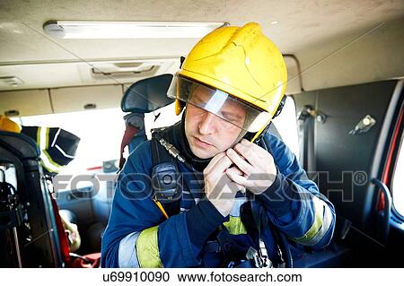 Fireman putting on helmet in fire engine View Large Photo Image Stock Image - Fireman putting on helmet in fire engine. Fotosearch