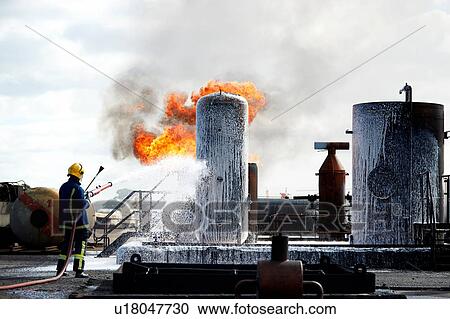 Stock Image - Fireman training to put out fire on burning tanks, Darlington, UK. Fotosearch