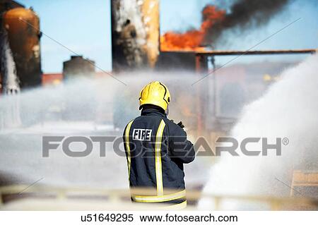 Stock Photography - Fireman training to put out fire on burning tanks, Darlington, UK. Fotosearch