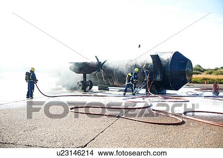 Firemen putting out fire on old training aeroplane, Darlington, UK View Large Photo Image Picture - Firemen putting out fire on old training aeroplane, Darlington, UK. Fotosearch