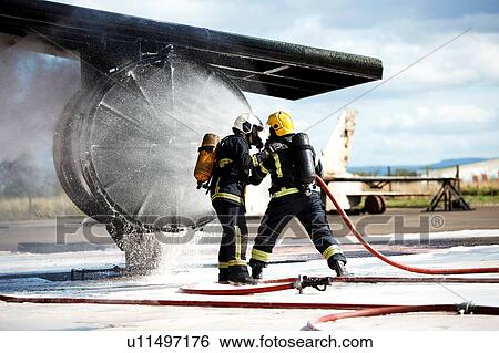 Stock Photograph - Firemen putting out fire on old training aeroplane, Darlington, UK. Fotosearch