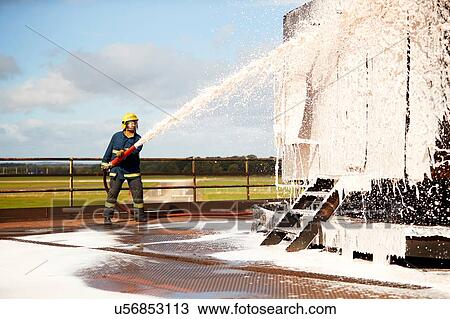 Firemen training, fireman spraying firefighting foam at training facility View Large Photo Image Stock Image - Firemen training, fireman spraying firefighting foam at training facility. Fotosearch