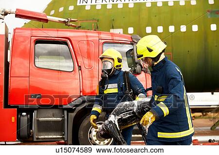 Firemen training, firemen in breathing apparatus carrying equipment View Large Photo Image Stock Photo - Firemen training, firemen in breathing apparatus carrying equipment. Fotosearch