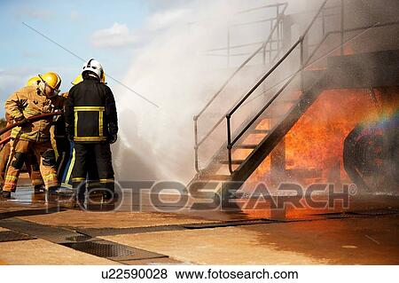 Firemen training, firemen spraying water at training facility stairway View Large Photo Image Stock Photo - Firemen training, firemen spraying water at training facility stairway. Fotosearch