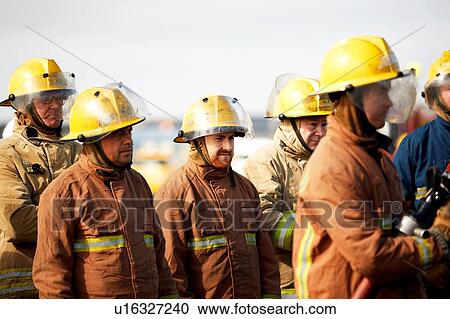 Stock Image - Firemen training, group of firemen listening to instructions. Fotosearch