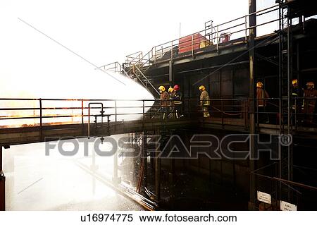Firemen training, on training facility raised walkway spraying water on fire View Large Photo Image Stock Photography - Firemen training, on training facility raised walkway spraying water on fire. Fotosearch