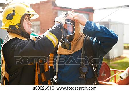 Firemen training, supervisor helping fireman with breathing apparatus at training facility View Large Photo Image Stock Image - Firemen training, supervisor helping fireman with breathing apparatus at training facility. Fotosearch