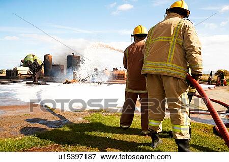 Firemen training, team of firemen spraying firefighting foam at training facility View Large Photo Image Stock Photo - Firemen training, team of firemen spraying firefighting foam at training facility. Fotosearch
