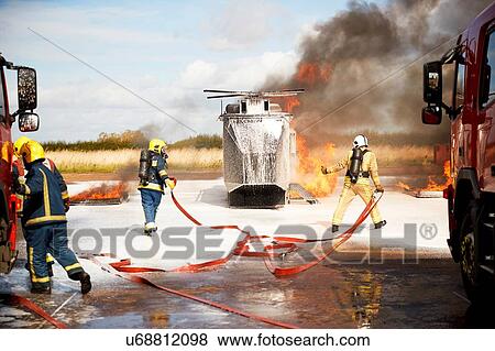 Firemen training, team of firemen extinguishing mock helicopter fire at training facility View Large Photo Image Stock Photo - Firemen training, team of firemen extinguishing mock helicopter fire at training facility. Fotosearch