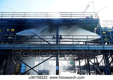 Stock Image - Firemen training to put out fire on burning building, Darlington, UK. Fotosearch
