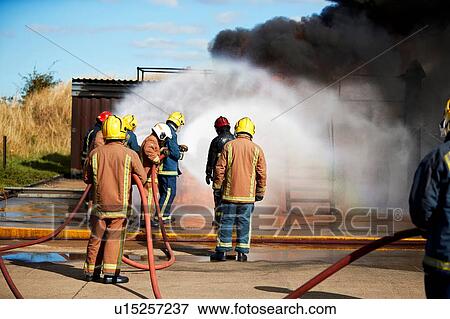 Stock Photo - Firemen training to put out fire on burning building, Darlington, UK. Fotosearch