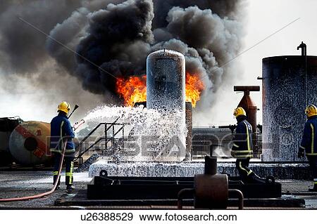 Firemen training to put out fire on burning tanks, Darlington, UK View Large Photo Image Stock Photo - Firemen training to put out fire on burning tanks, Darlington, UK. Fotosearch
