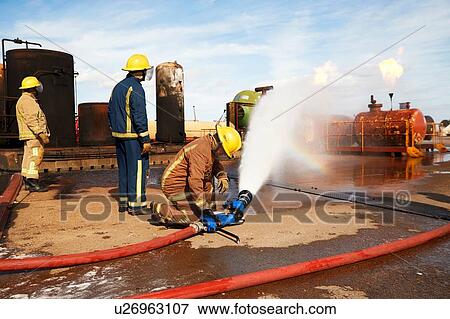 Stock Photo - Firemen training to put out fire on burning tanks, Darlington, UK. Fotosearch